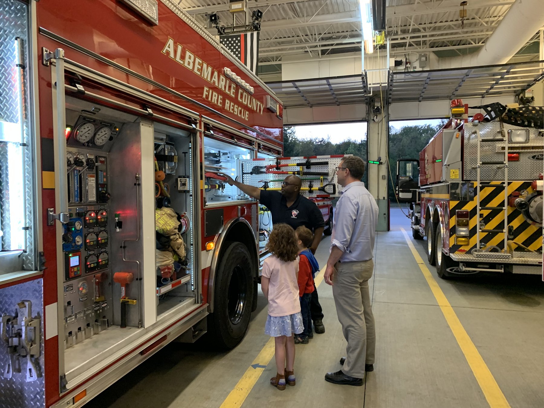 Albemarle County firefighter shows apparatus to community members visiting the station